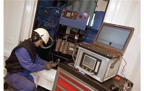 SDMO laboratory technician in test phase on the monitoring & command cabinet of a generating set in a container